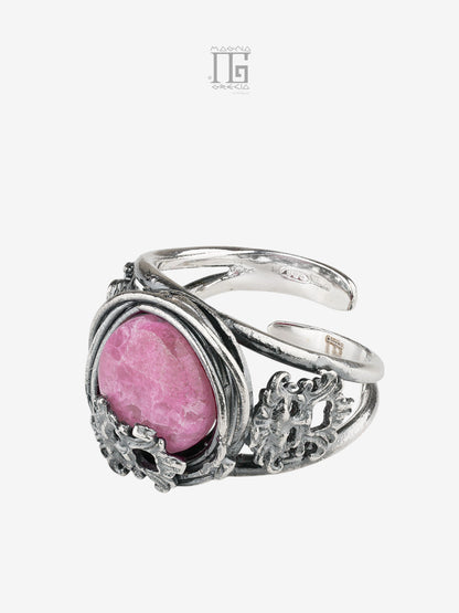 Vista sinistra dell'Anello Aion in argento 925 con pietra fucsia, filo intrecciato e maschere apotropaiche